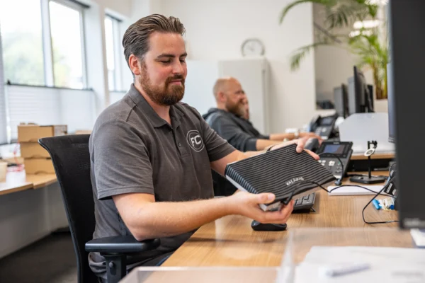 Roy, een van de engineers, installeert een modem router van Draytek